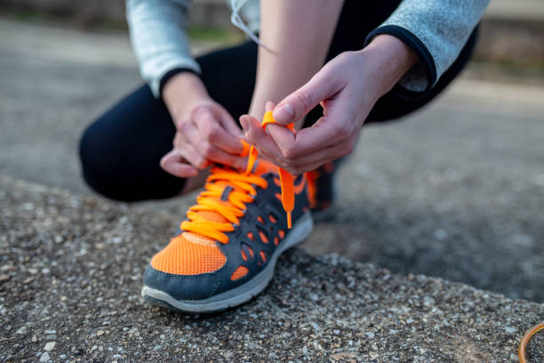 istock young woman trail runner tying shoelaces 1130239322