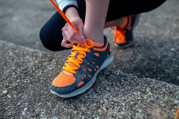 istock young woman trail runner tying shoelaces 1130240533