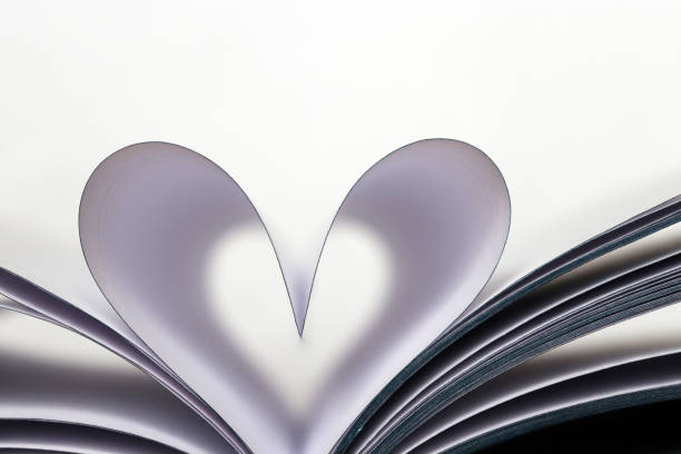istock Open book with heart shape from paper pages isolated on white background 1130243249