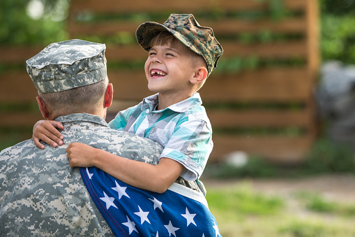 Military man father hugs son. Portrait of happy american family. focus on fathers back