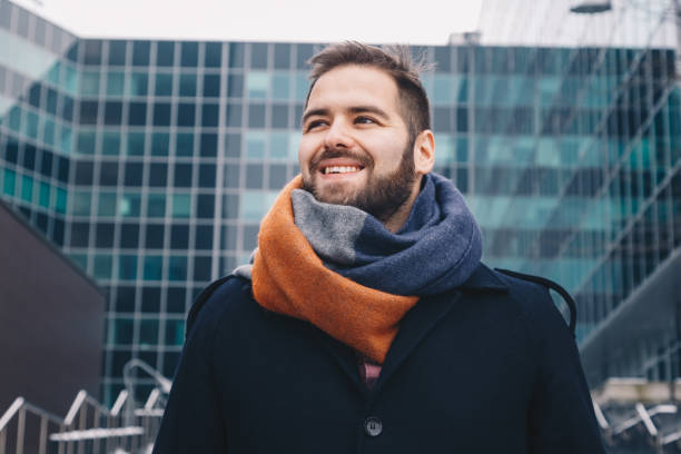 istock man posing in front of a modern day building. 1130246667