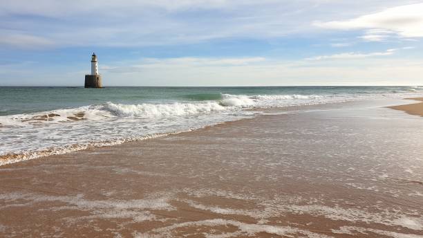istock White lighthouse on platform in sea near beach 1130246790