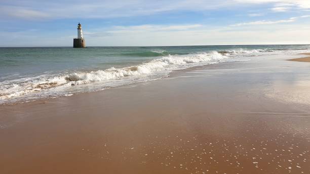 istock White lighthouse on platform in sea near beach 1130246804