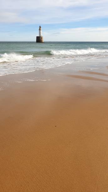 istock White lighthouse on platform in sea near beach 1130246810