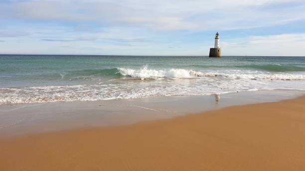 istock White lighthouse on platform in sea near beach 1130246821