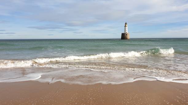istock White lighthouse on platform in sea near beach 1130246829
