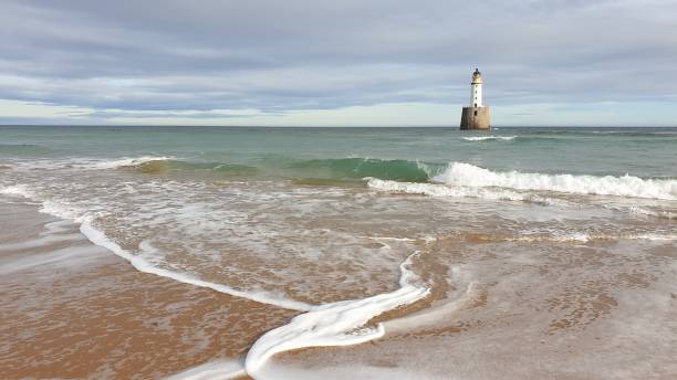 istock White lighthouse on platform in sea near beach 1130246842