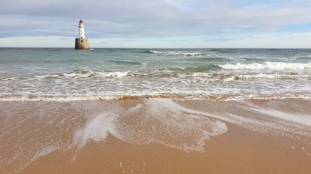 istock White lighthouse on platform in sea near beach 1130246844