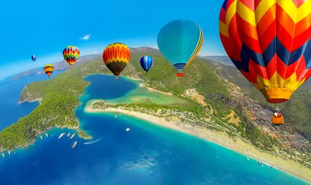 Photo of Hot air balloon flying over spectacular Blue Lagoon in Oludeniz, Turkey.