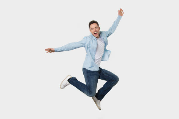 istock Happy cheerful young man jumping feeling joy isolated on background 1130250075