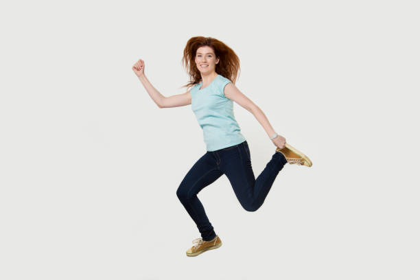 istock Happy active fit woman running hurrying jumping in air 1130250085