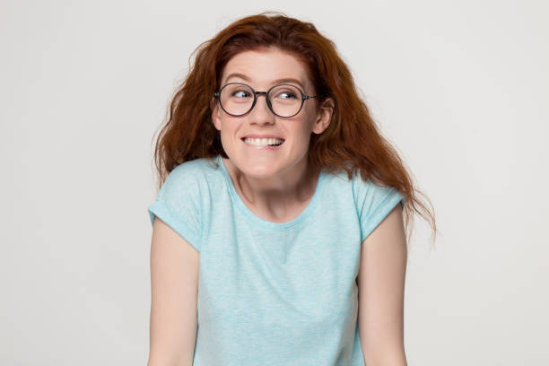 istock Cute shy redhead girl in glasses biting lips feeling embarrassed 1130250097