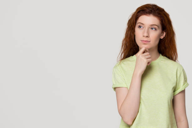 istock Thoughtful doubtful redhead woman with unsure face looking at copyspace 1130250127