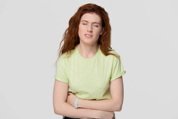 istock Sick upset redhead woman feeling stomach ache holding belly 1130250129