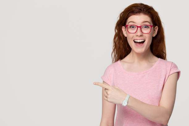istock Excited happy red-haired woman customer pointing finger at copy space 1130250145