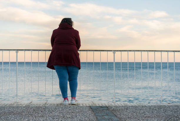 Young fat woman standing alone on the beach
