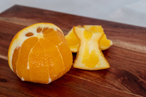 istock half peeled orange lying on a wooden kitchen board 1130258656