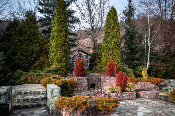 istock Stone fountain with colorful evergreen plants 1130259690