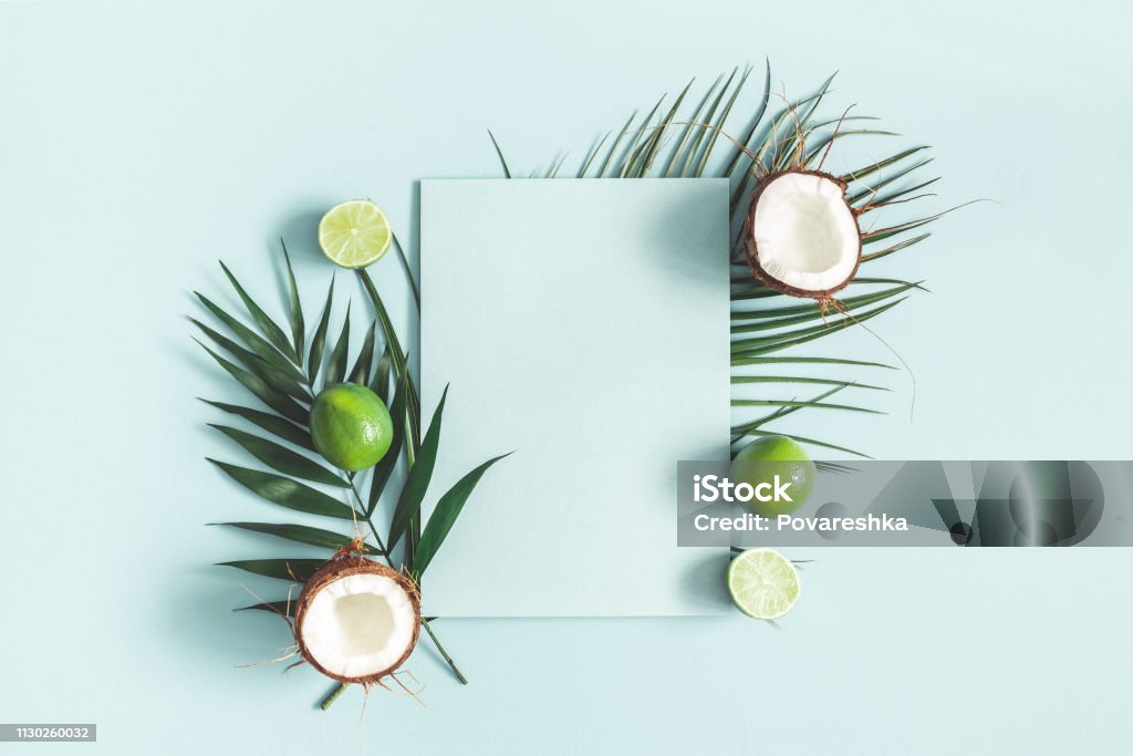 Summer composition. Tropical palm leaves, fruits, paper blank on pastel blue background. Summer concept. Flat lay, top view, copy space Summer Stock Photo