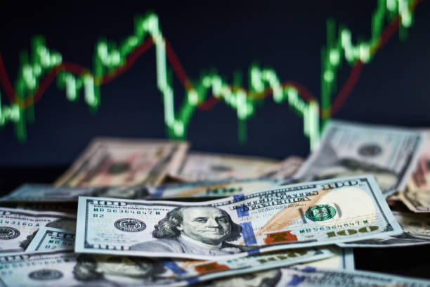 us dollar bills on a background with dynamics of exchange rates. trading and financial risk concept - símbolo do dólar imagens e fotografias de stock