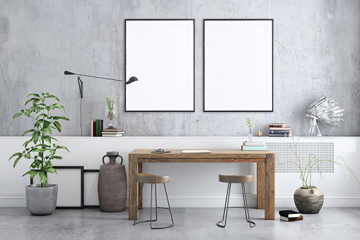 Freelancer home studio interior. Wooden desk. Blank picture poster frame. Artist designer background template.