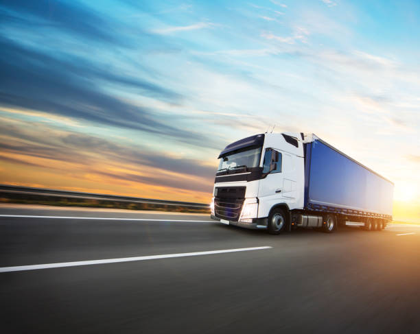 cargado europeo de camiones en autopista en puesta del sol - freight transportation driving truck highway fotografías e imágenes de stock