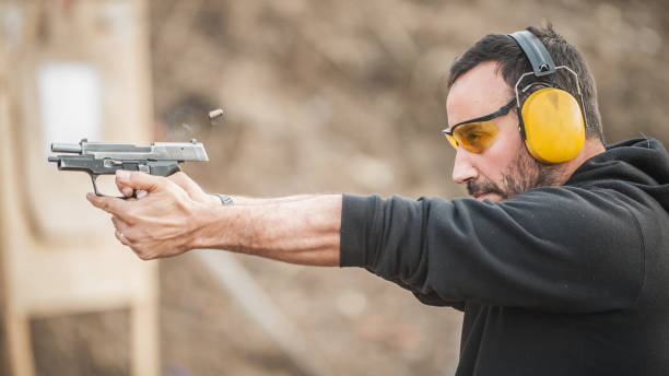 tirador con pistola y tiro táctico de entrenamiento. vista de detalle de primer plano - target shooting gun handgun shooting fotografías e imágenes de stock