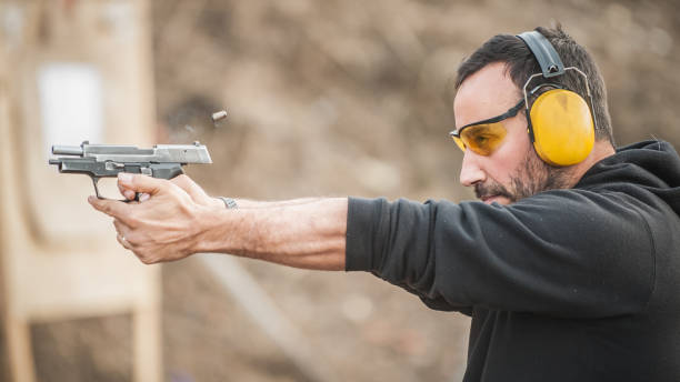 Shooter holding gun and training tactical shooting. Close-up detail view Detail view of shooter holding gun and training tactical shooting, close up. Shooting range target shooting photos stock pictures, royalty-free photos & images