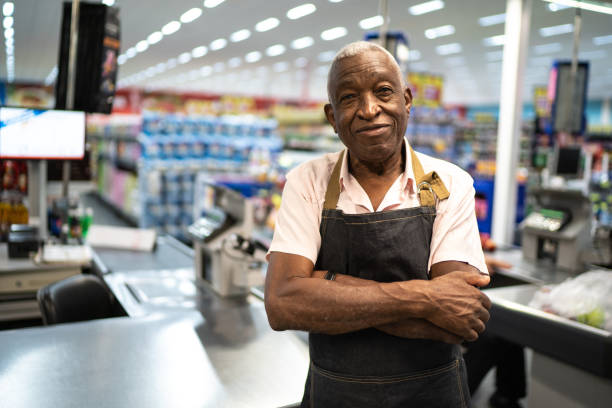 afro senior woman geschäftsinhaber / mitarbeiter in supermarkt - sales clerk store manual worker retail stock-fotos und bilder