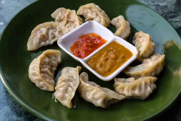 Traditional asian food. Nepalese steamed dumpling momo served with tomato chutney.