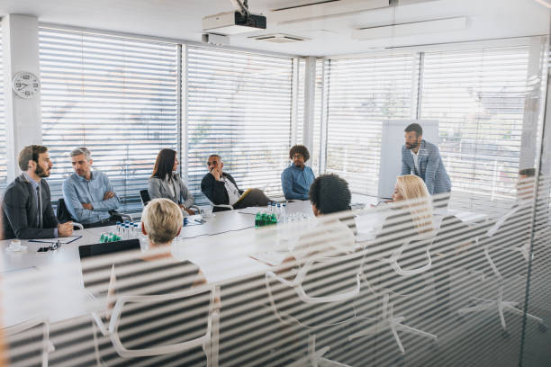 istock Male CEO communicating with his colleagues during a presentation in a board room. 1130266255