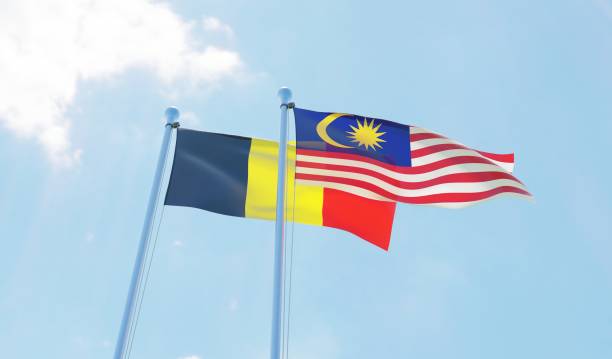 istock Malaysia and Belgium, two flags waving against blue sky 1130268384