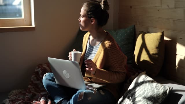 Pretty Young Woman Drinking Coffee And Working From Home in Cozy Sunny Atmosphere