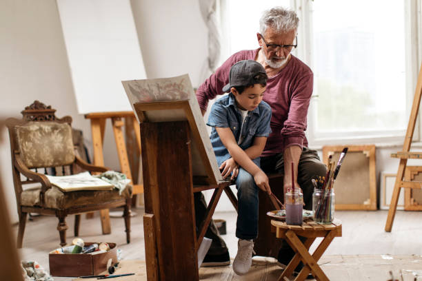 istock Kid and his grandfather mixing paint 1130271163