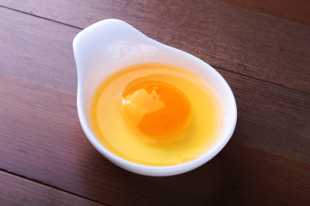 istock egg yolk in a white bowl and raw egg on the table. ingredients for cooking. concept. View from above. 1130271458