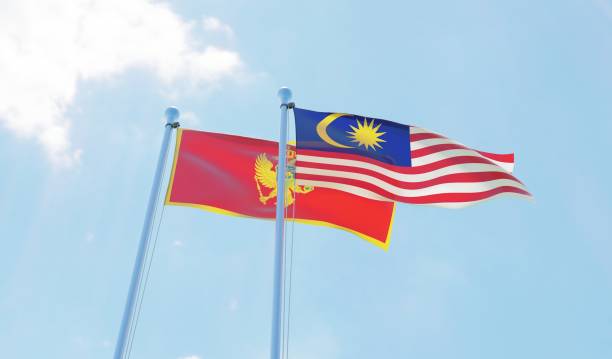 istock Malaysia and Montenegro, two flags waving against blue sky 1130272334