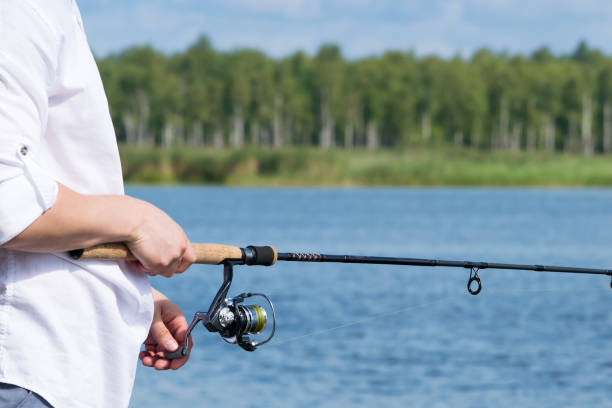 istock fisherman catches fish on the lake on spinning close-up, background 1130272421