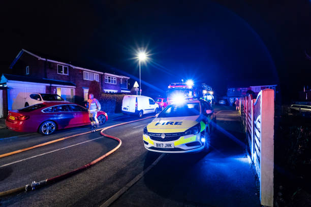 bomberos y bomberos asisten un emergencia incendio en una urbanización tranquila en la ciudad causada por un cableado de lavadora falla - uk fire department fire engine team fotografías e imágenes de stock