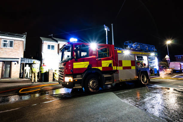 bomberos y bomberos asisten un emergencia incendio en una urbanización tranquila en la ciudad causada por un cableado de lavadora falla - uk fire department fire engine team fotografías e imágenes de stock