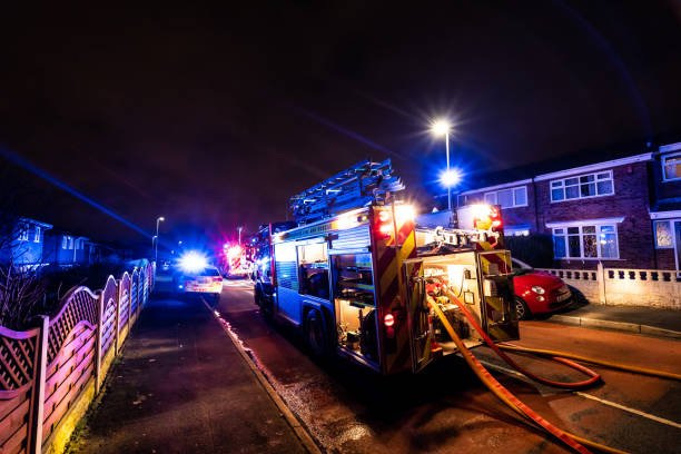 bomberos y bomberos asisten un emergencia incendio en una urbanización tranquila en la ciudad causada por un cableado de lavadora falla - uk fire department fire engine team fotografías e imágenes de stock