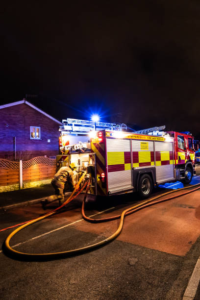 bomberos y bomberos asisten un emergencia incendio en una urbanización tranquila en la ciudad causada por un cableado de lavadora falla - uk fire department fire engine team fotografías e imágenes de stock