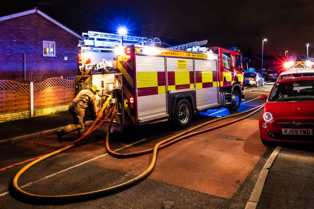 bomberos y bomberos asisten un emergencia incendio en una urbanización tranquila en la ciudad causada por un cableado de lavadora falla - uk fire department fire engine team fotografías e imágenes de stock