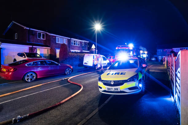 bomberos y bomberos asisten un emergencia incendio en una urbanización tranquila en la ciudad causada por un cableado de lavadora falla - uk fire department fire engine team fotografías e imágenes de stock