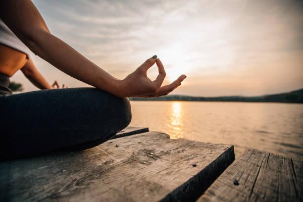 istock Meditating by the lake in sunset 1130278842