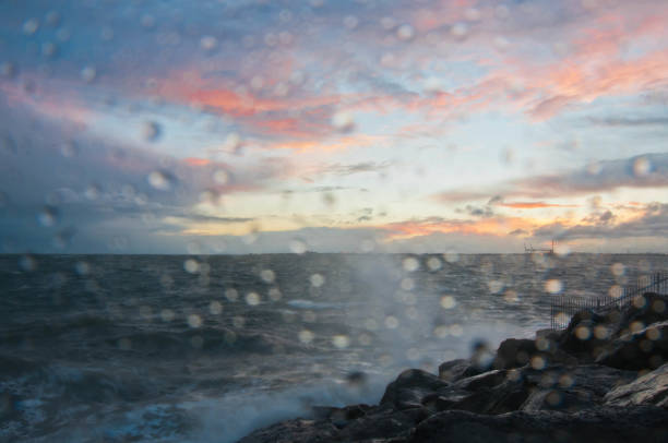 drammatica onda oceanica schizzo la sera con cielo crepuscolare in inverno al breakwater al molo di st kilda a melbourne in australia - melb foto e immagini stock