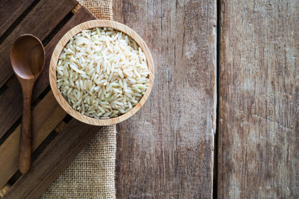 raw brown whole grain semi-milled rice in wood bowl - gunny sack imagens e fotografias de stock