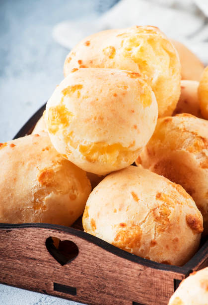 istock Appetizing homemade golden cheese buns on gray kitchen table, selective focus. Magazine style. Place for text 1130281412
