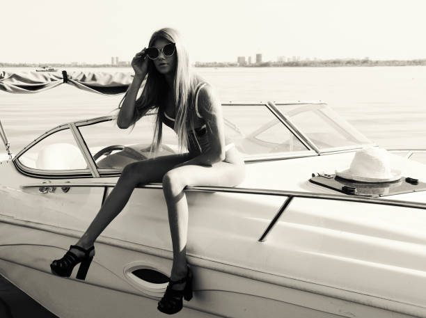 Rest beautiful girl by the water on a motor boat. Monochrome image in retro style.