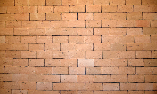 Surface of a yellow brick wall.