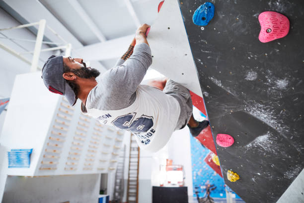 istock Indoor climbing, Man climbing indoor boulder wall. 1130286174